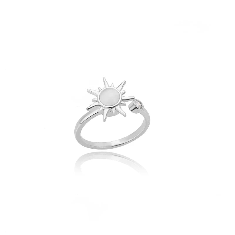 Silver ring with sun design on a white background